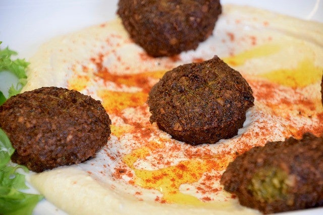 falafel on a pita over hummus, yogurt and paprika