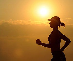 Female running with sunset in background